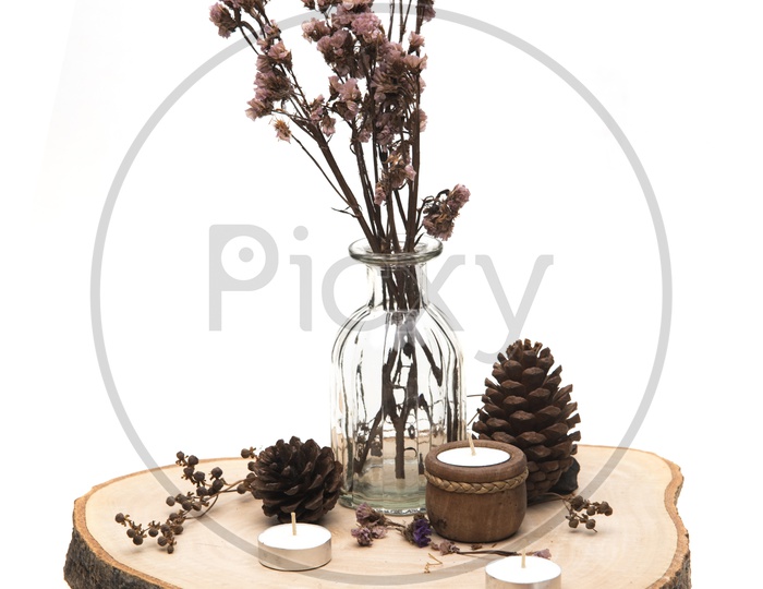 Dried flowers in a glass vase and candles on a wooden table isolated on white background