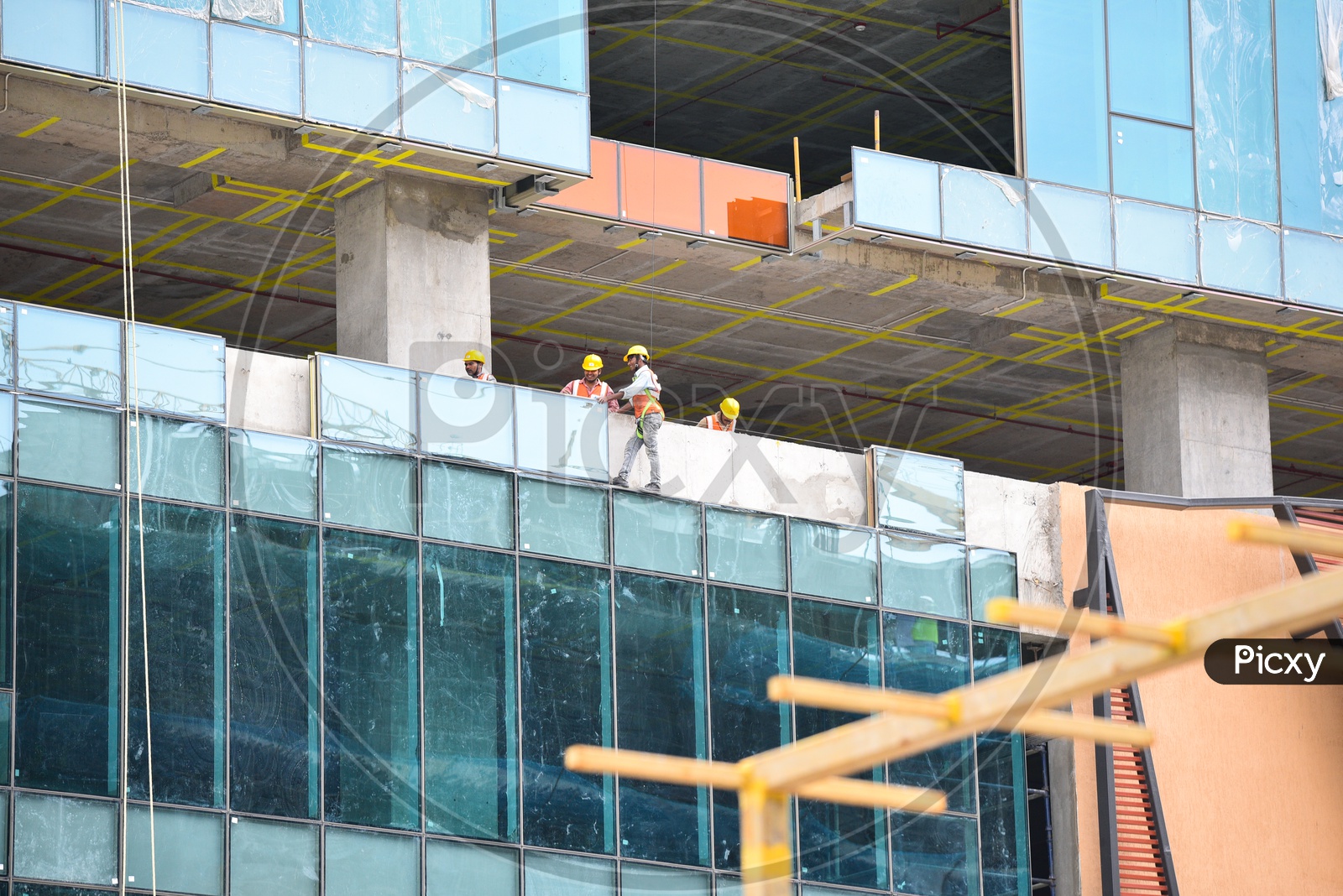 Construction Workers Fixing Building Facade Glass