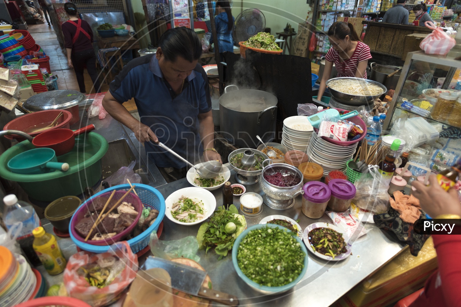 A Street Food Vendor Preparing fast food At a Stall