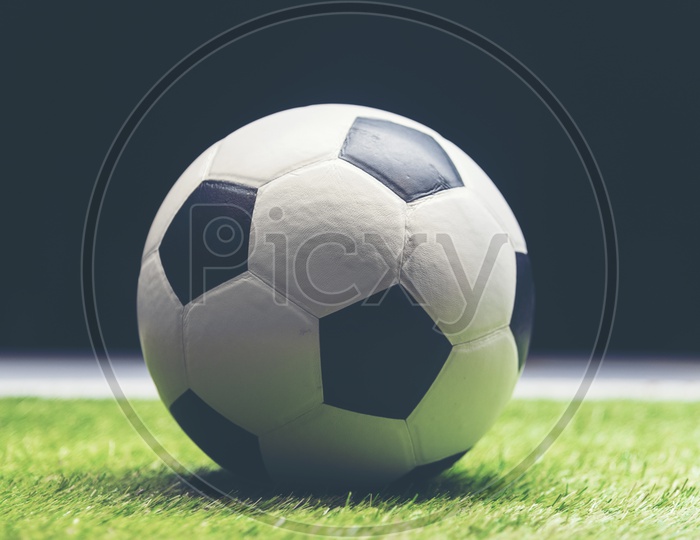 Soccer ball on grass isolated on black background
