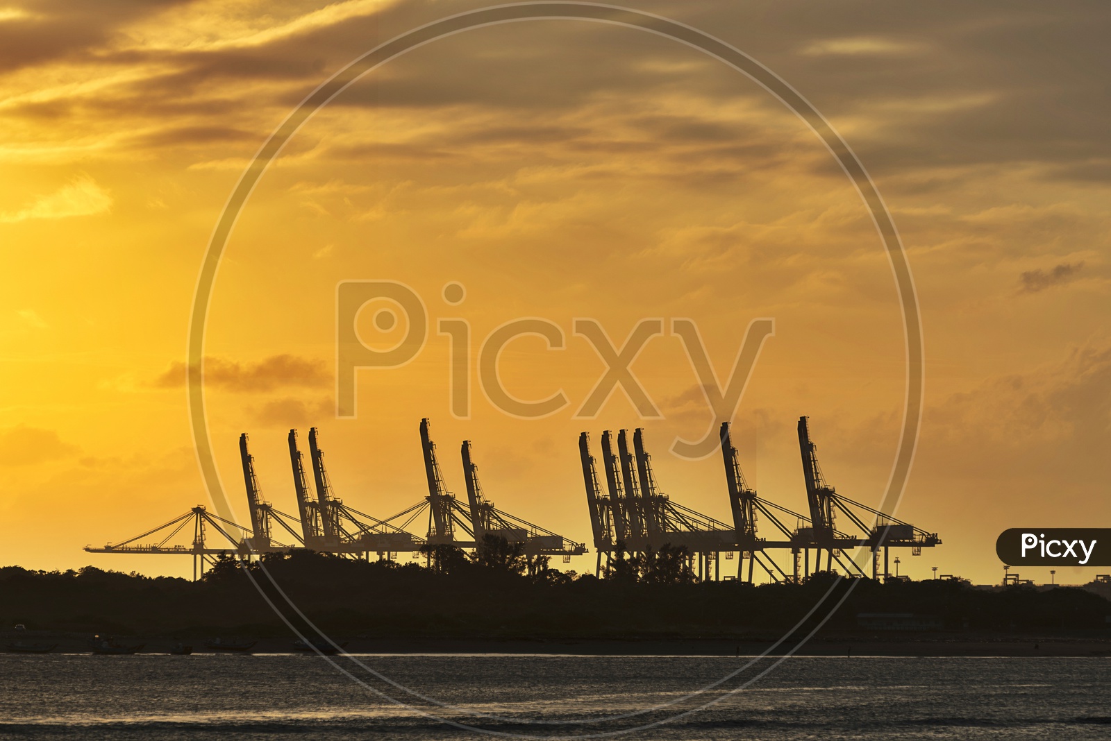 Heavy Cranes Silhouette In a Port or Harbor With Sunset Sky in Background