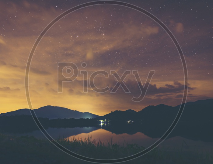 landscape of night sky With Galaxy Star Gazing over the lake With Gold  Sky