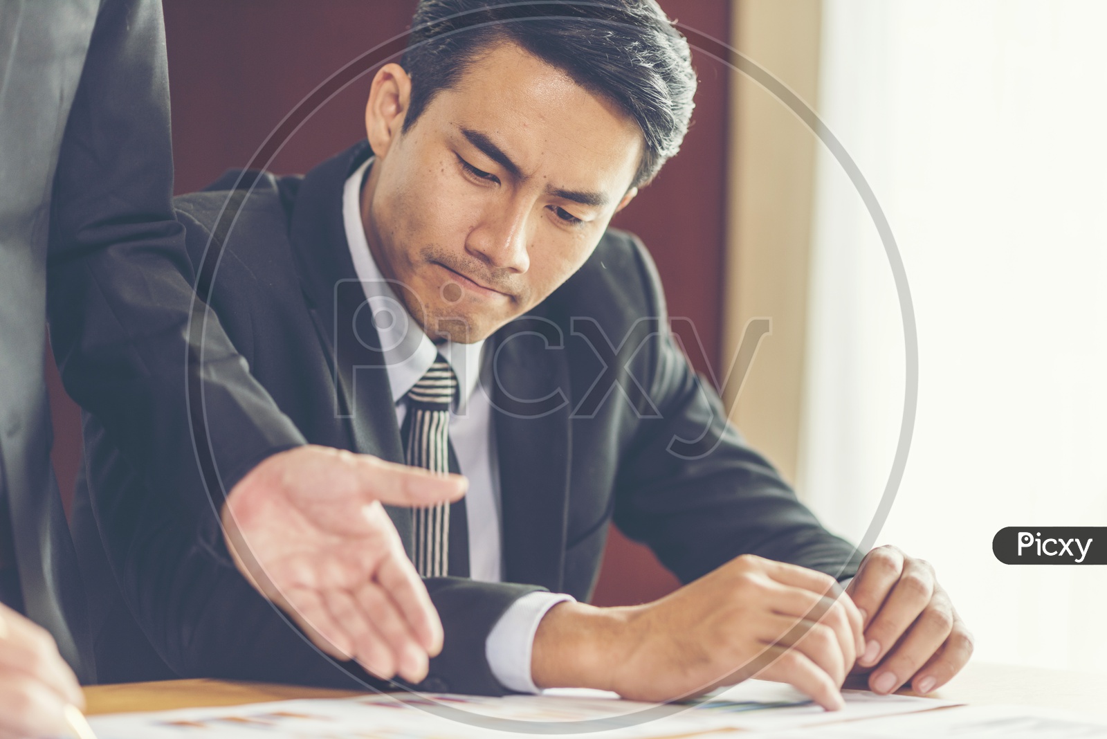 Professional man looking into the project documents shown by another person