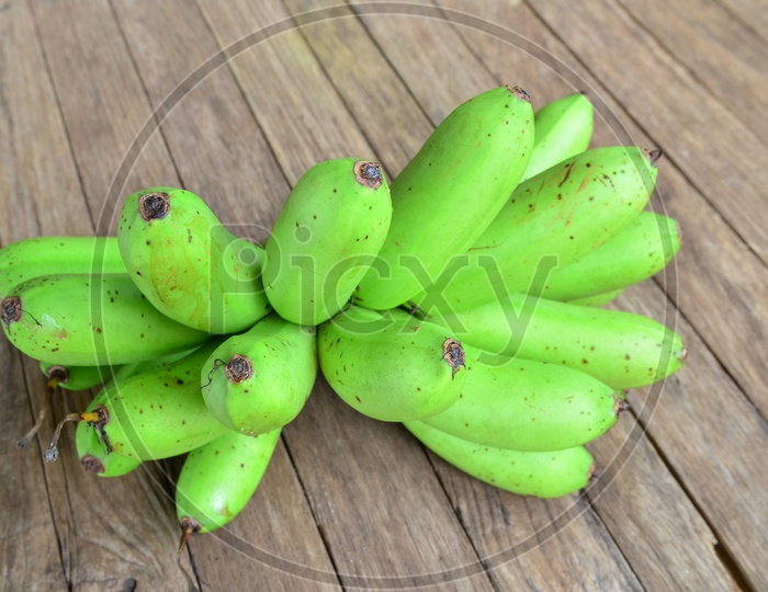 Bunch of Green Bananas On an Wooden Table Background