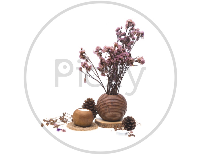 Dried pink flowers in a wooden vase and candles isolated on white background