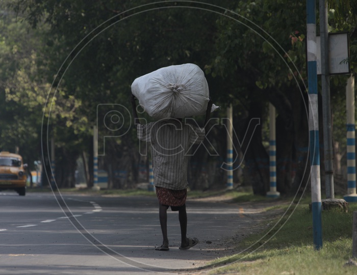 Indian Man carrying a bag full of load on his head