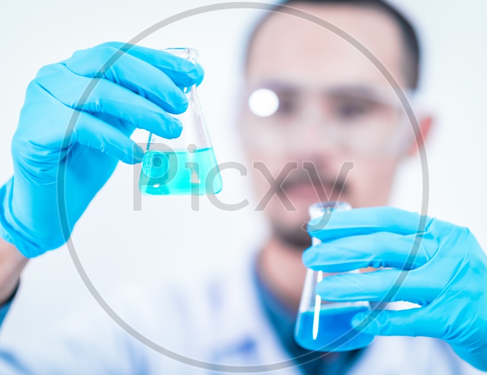 Young Asian Male Scientist or Student Experimenting in a Chemical Laboratory