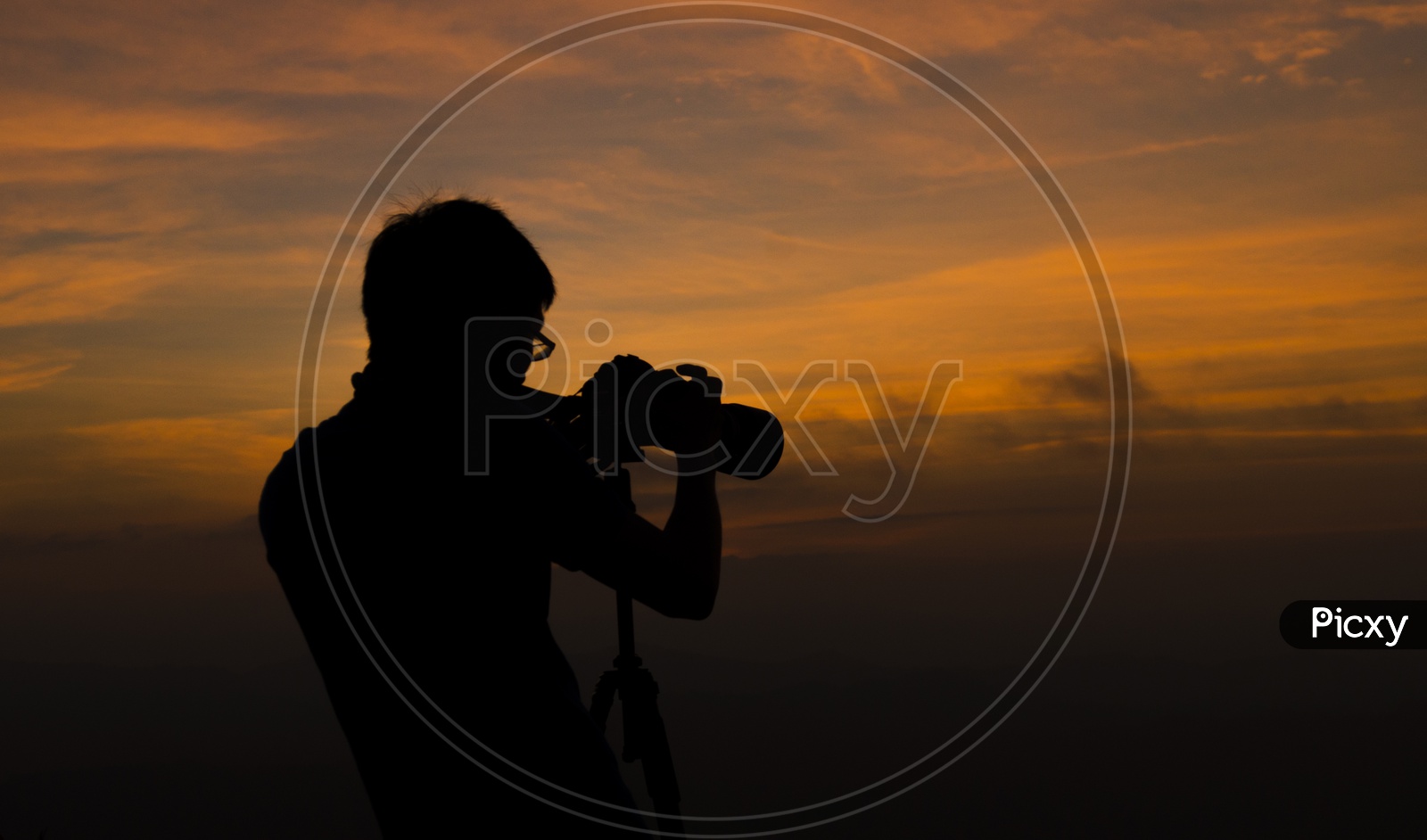 Silhouette of a Photographer Over Sunset Sky