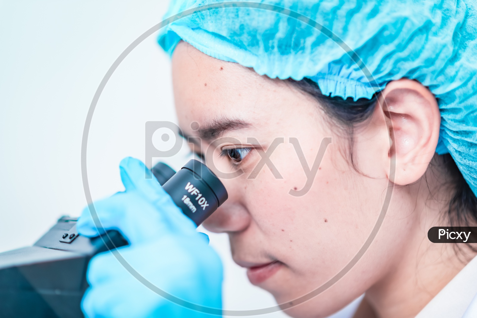 Young Asian Female Scientist Looking into Microscope