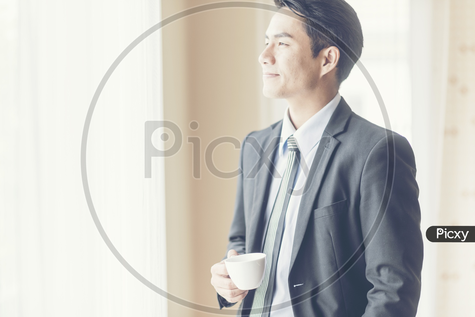 Businessman Drinking Coffee at Office And Relaxing By looking Through Office Window Calmly