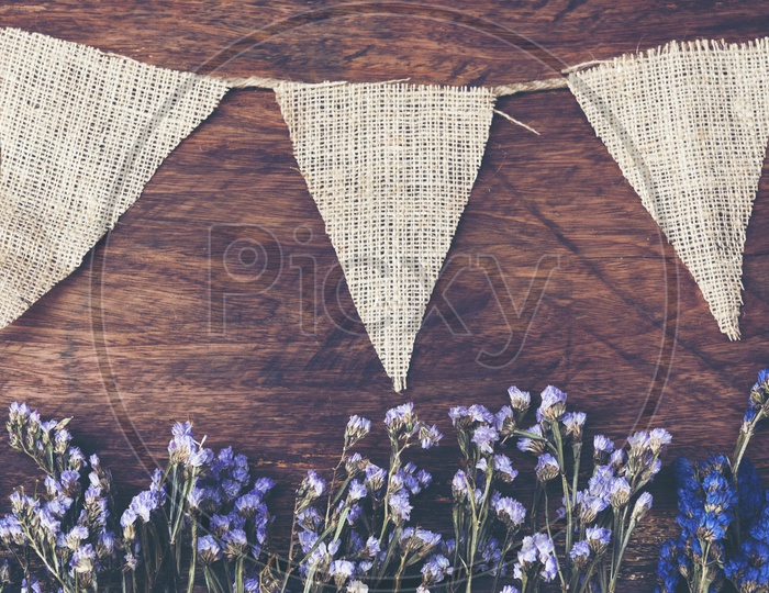 vintage wooden background with dry flowers and jute flags