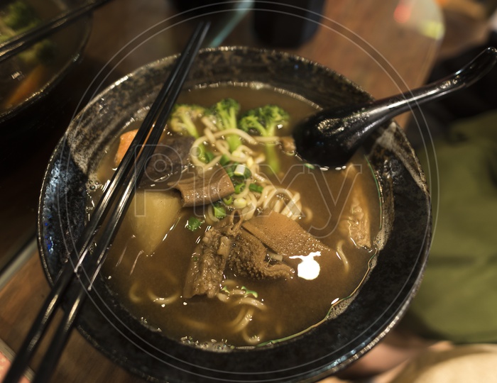 Pork Belly and Noodles Soup in a Bowl with Broccoli