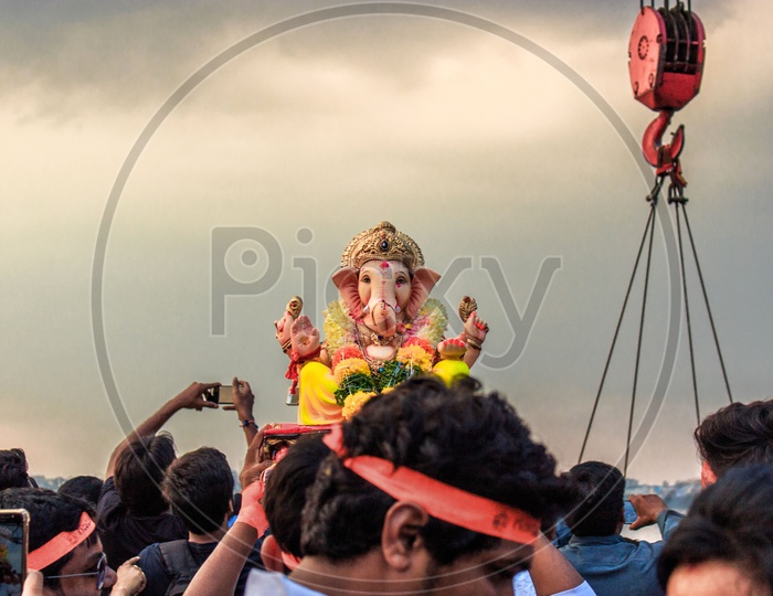 person carrying ganesha idol on his head