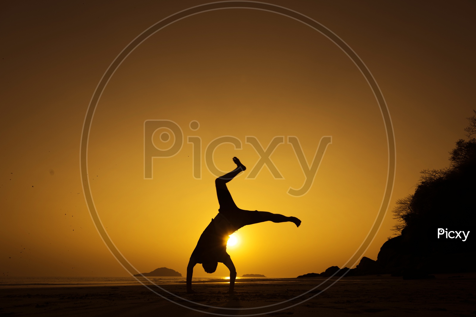 Silhouette Of a Boy  Happily jumping Over a Golden Sky In Background
