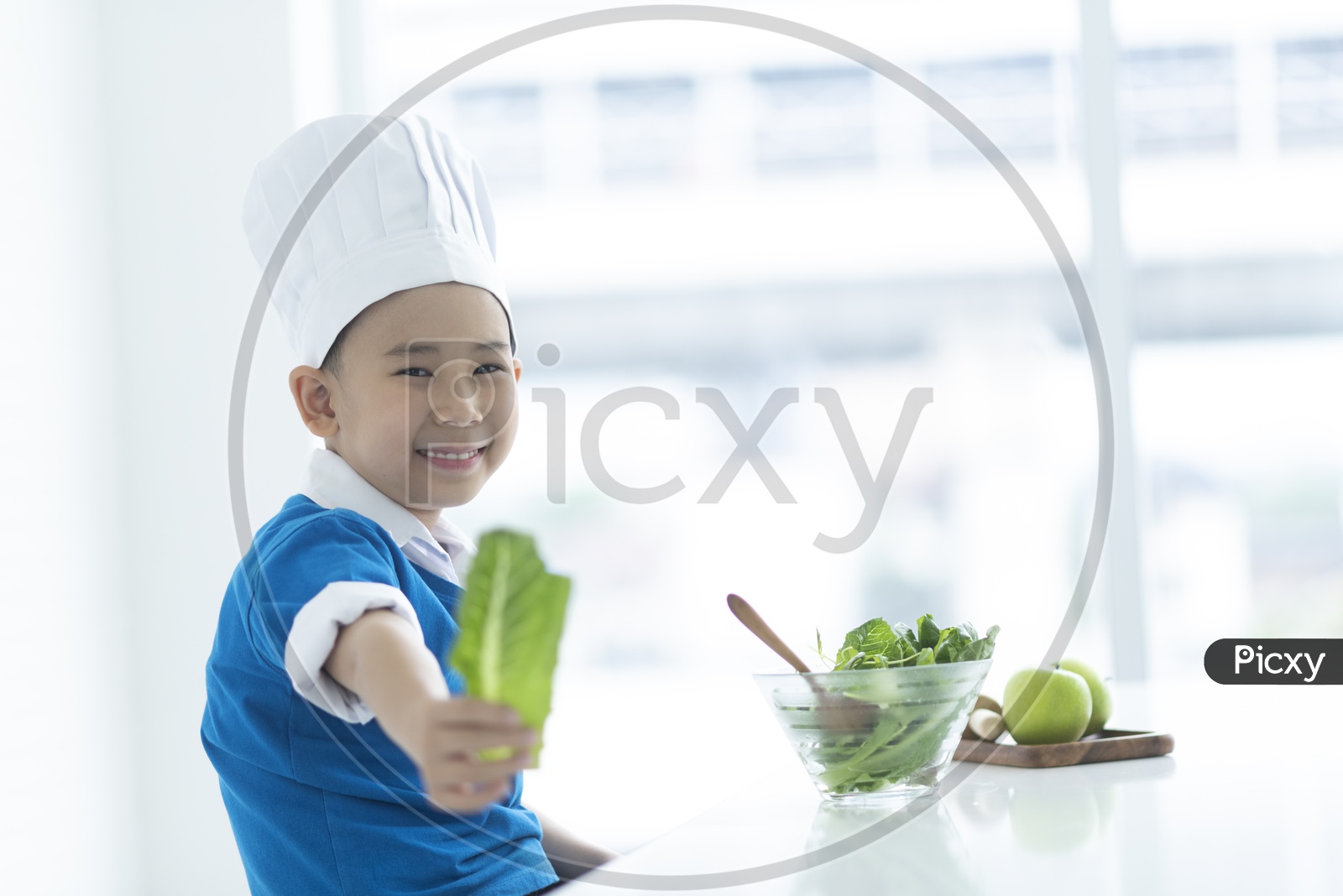A boy as a chef smiling & enjoying cooking - cooking concept