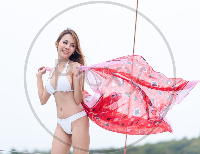 Asian Girl Posing In White Bikini Holding a Red Scarf