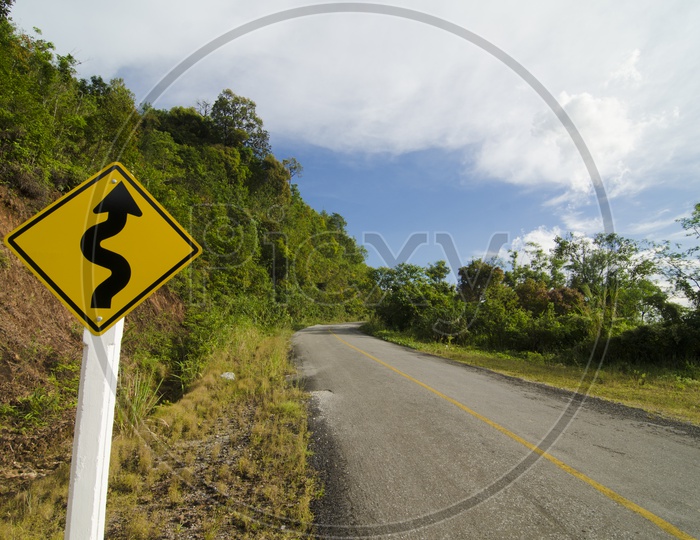 Zig-zag  Road Sign Or Warning  Board in a Terrain Or Ghat  Road