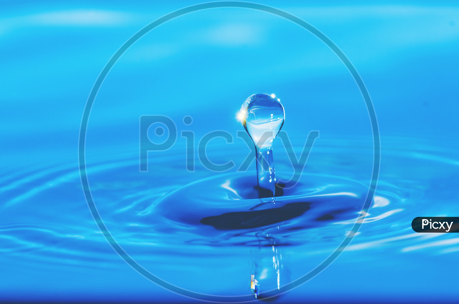 Water Splash With Droplet  On Blue surface