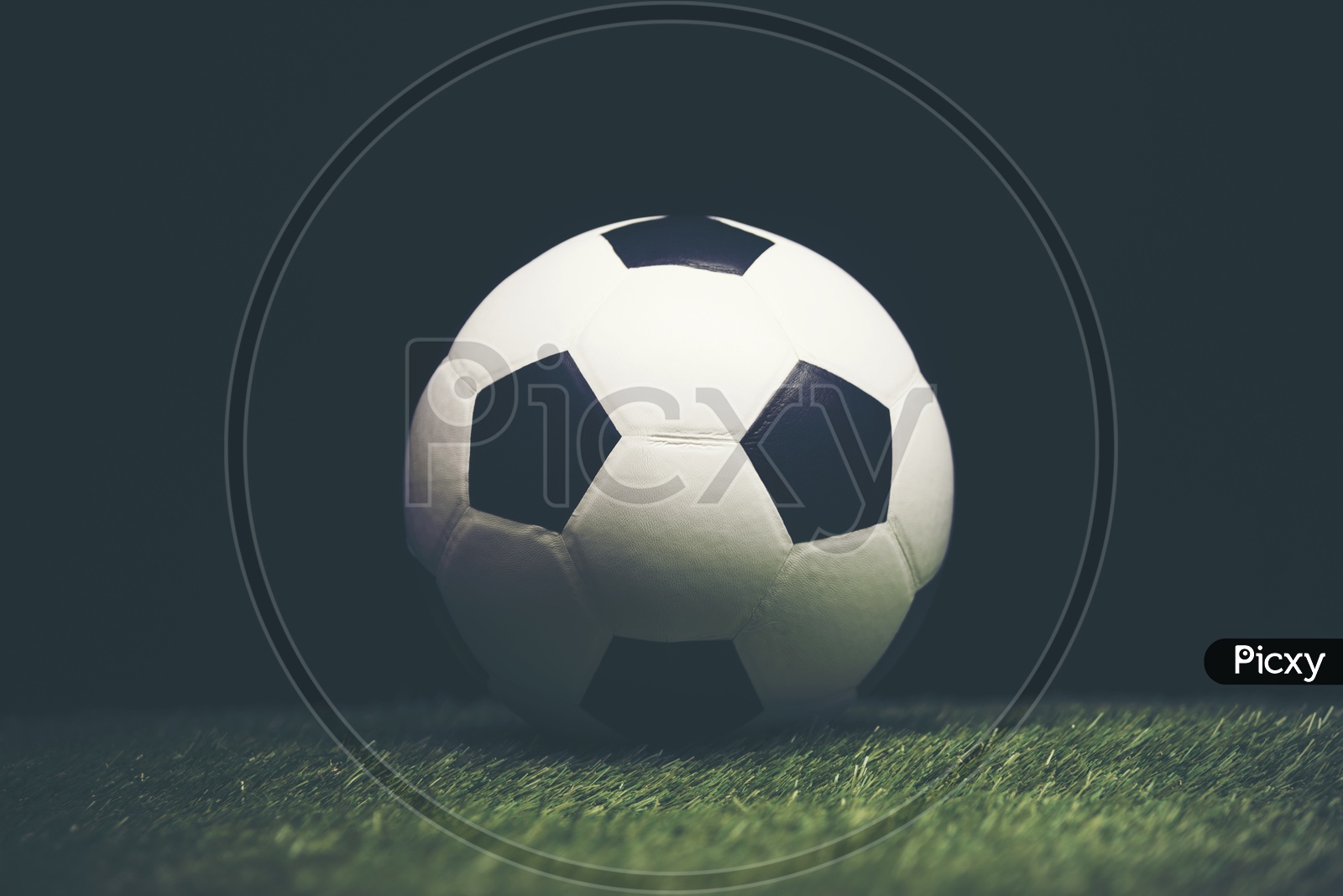 Soccer ball on grass with black background