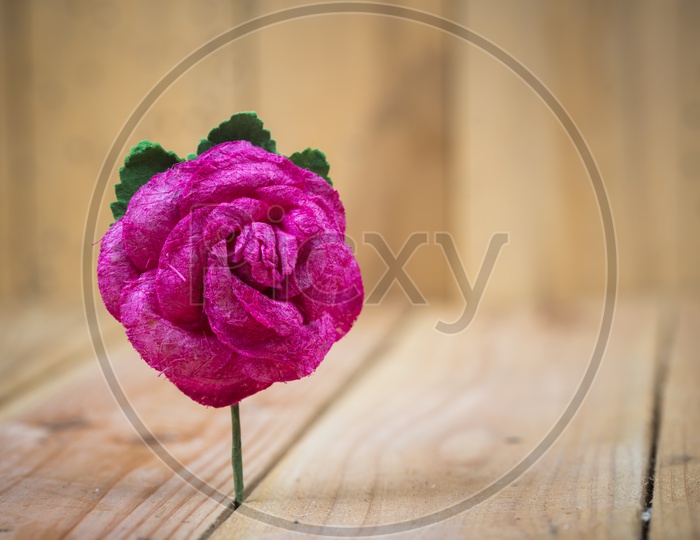 Artificial Rose Flower Closeup With Wooden Background