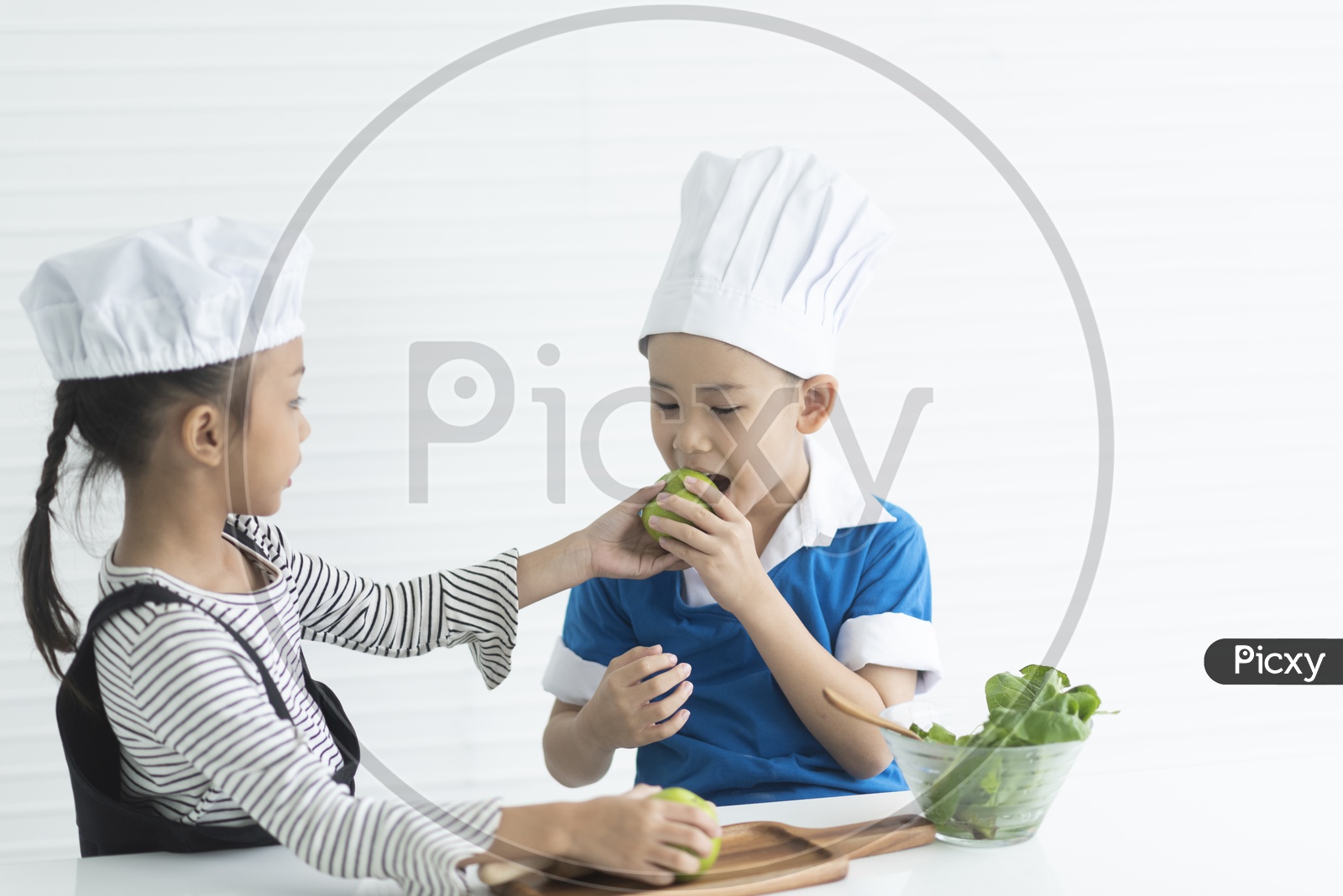 A boy and a girl are playing at little chefs -  cooking concept