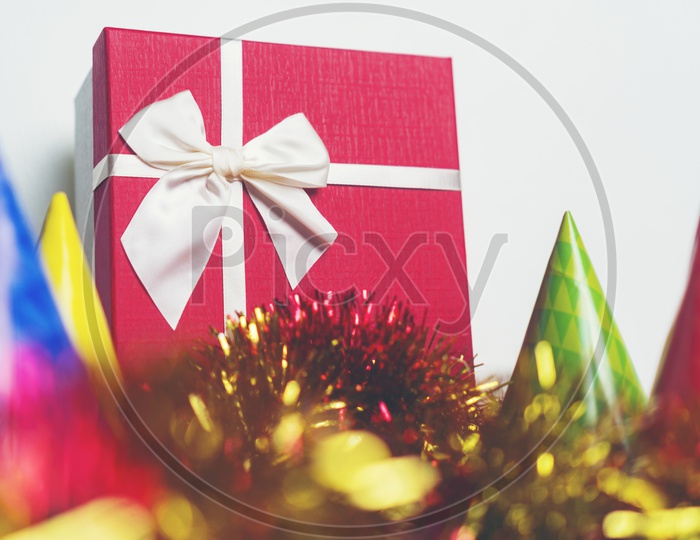 Christmas Gift Box With Decoration Colour Papers over a White Beige Wall Backdrop