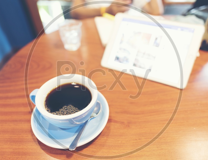 Black americano coffee in ceramic white cup on a wooden table