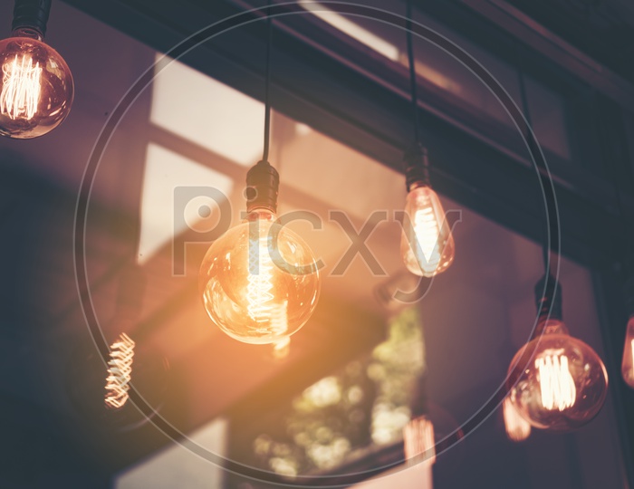 Decorative antique edison style light  bulbs against cafe wall background