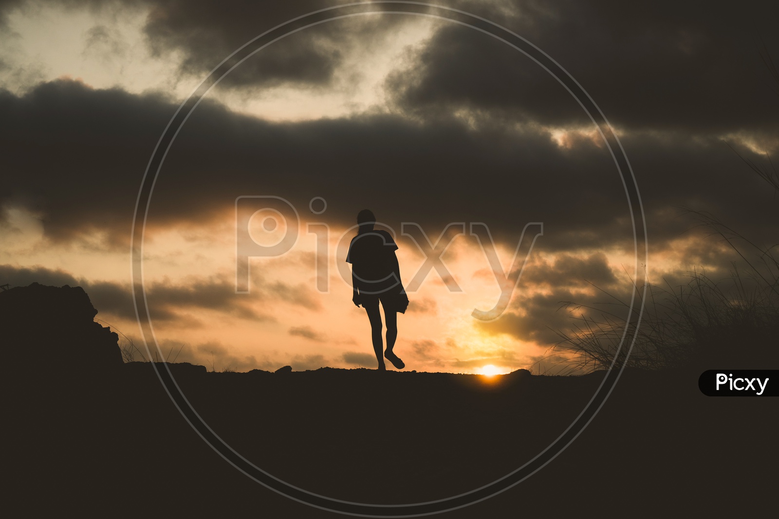 silhouette of lonely person walking with sunset Background