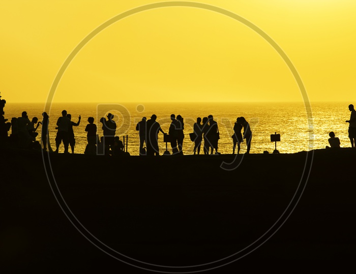 Silhouette of Group of  people At a Beach  With Sunset Sky in Background