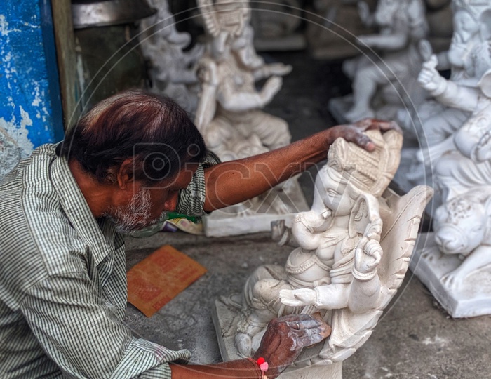 Artist in doing finishing touches to the Ganesh idol