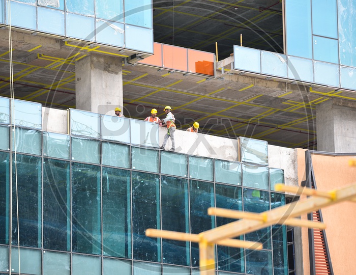 Construction Workers Fixing Building Facade Glass