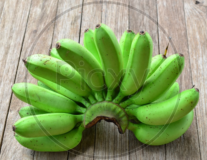 Bunch of Green Bananas On an Wooden Table Background