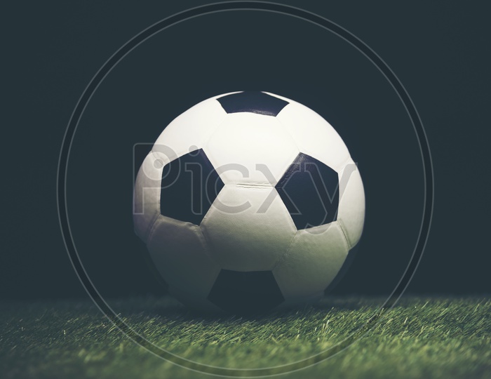Soccer ball on grass with black background