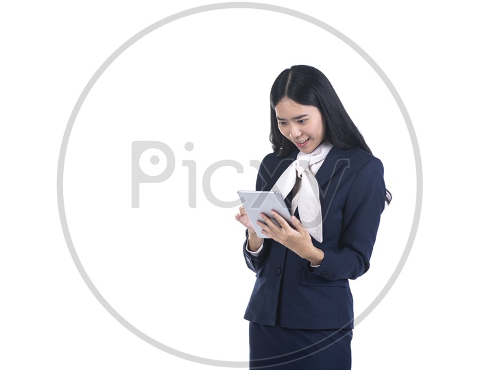Excited Business woman in a suit using a digital tablet on isolated background