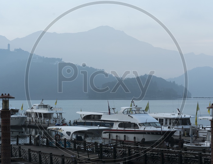 Tourist boats docking in peaceful morning at Shuishe Pier, Sun Moon Lake, Taiwan.