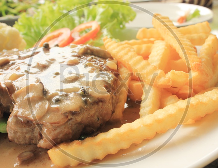 Grilled Beef steak with French Fries in a Plate