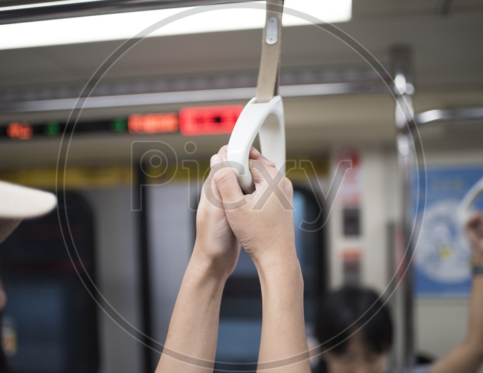 Commuters Hands Holding Support Handle bars in train Closeup