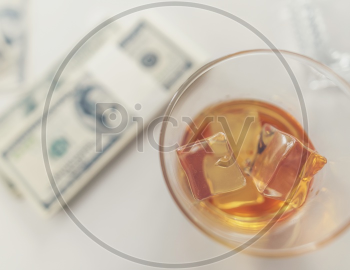 Whiskey Glass And money bundle On a Desk