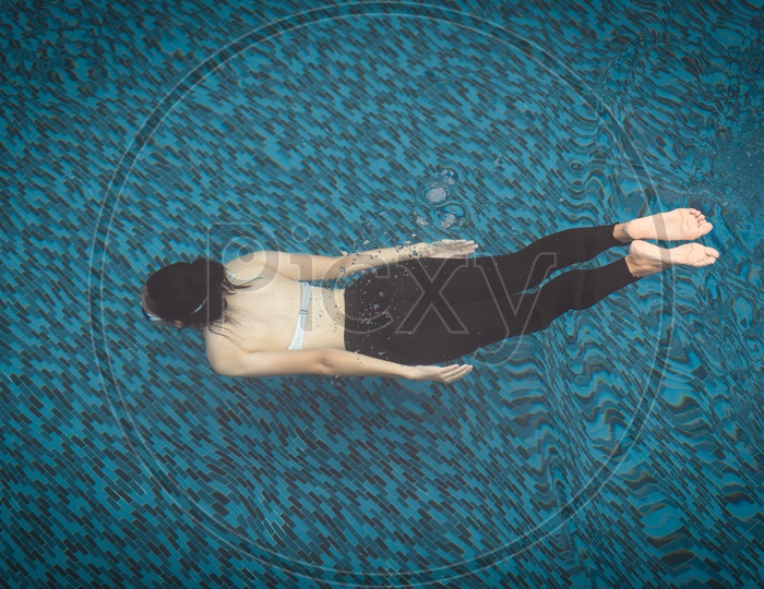 Woman Swimming In a Swimming Pool Top View
