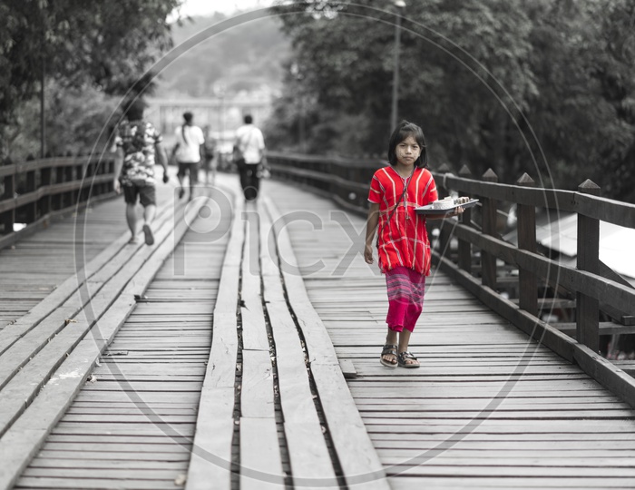 Mon Girl Child Vendor At Wooden Bridge  In Sangkhla Buri Province