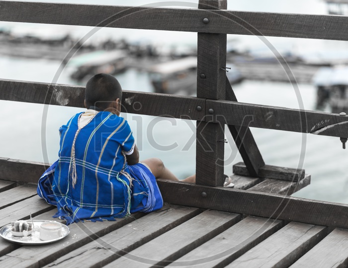 Mon Boy Sitting At Wooden Bridge in Sangkhla Buri