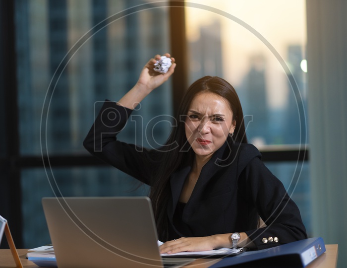 Frustrated Young Business Woman At Work Space Throwing Crushed Paper ball