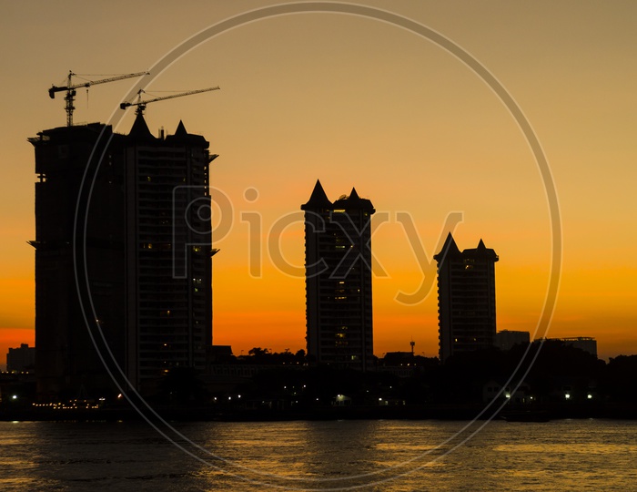 Sunset Over a City Scape And River View With High rise Buildings Silhouette