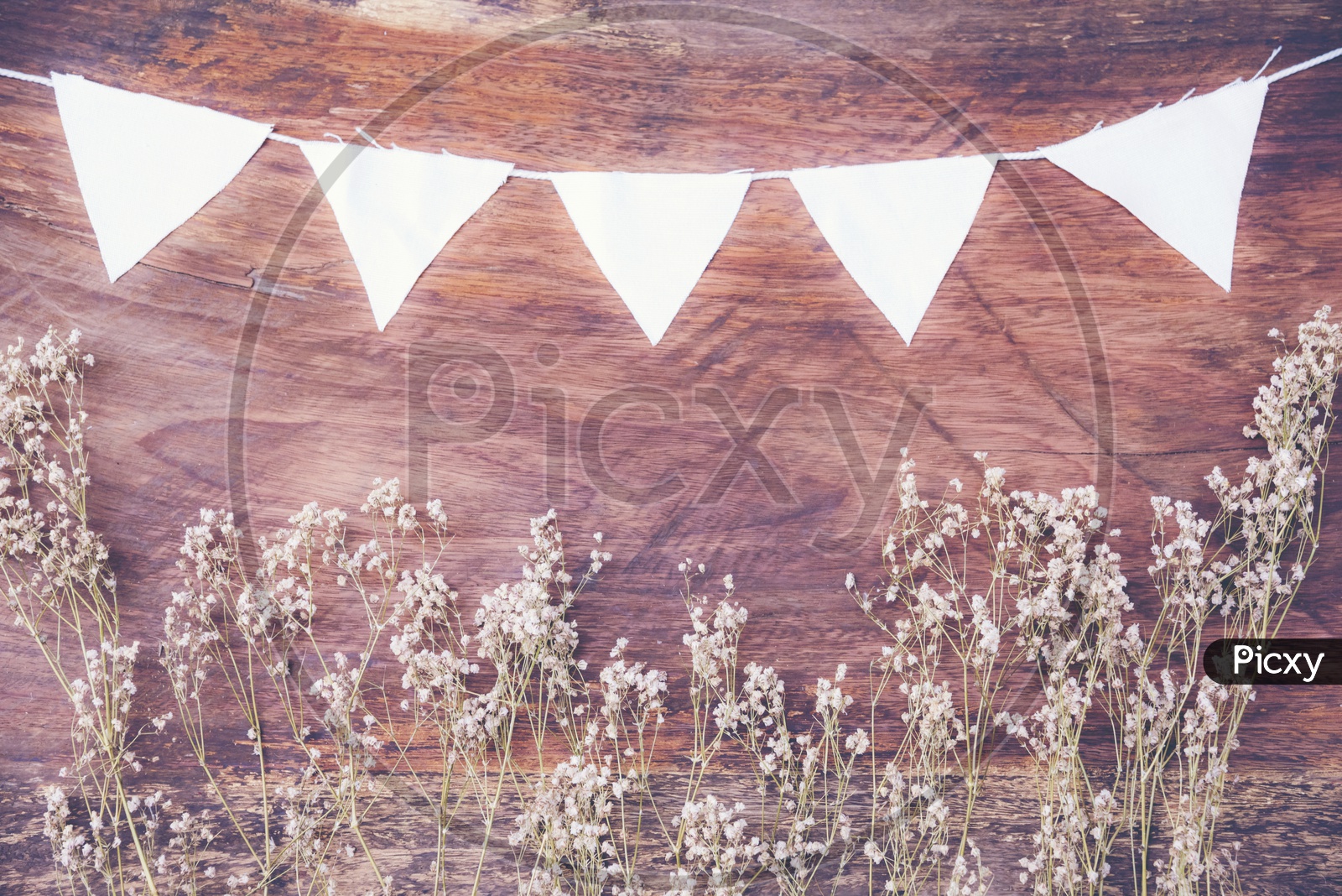 Dry grass and white flags frame on wood background