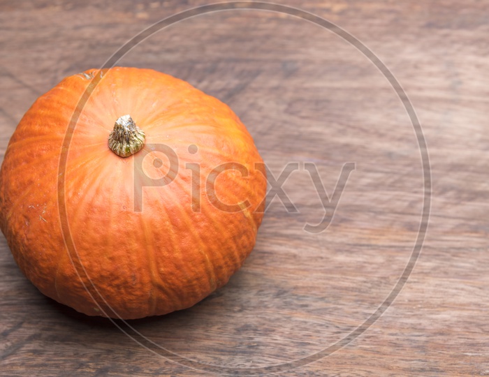 Orange raw pumpkin on wooden table background