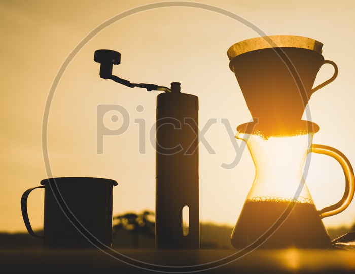 Silhouette of Coffee Drip Tools Over a Sunset background
