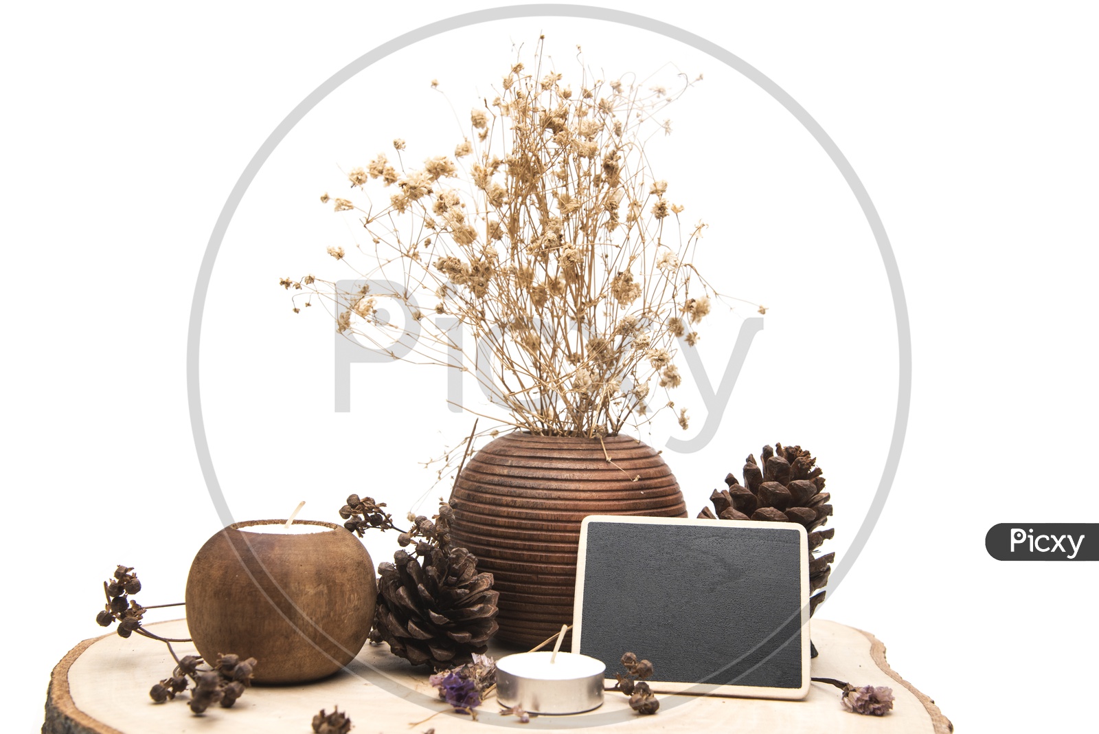 Dried flowers in a wooden vase and candles placed on a wooden table isolated on white background