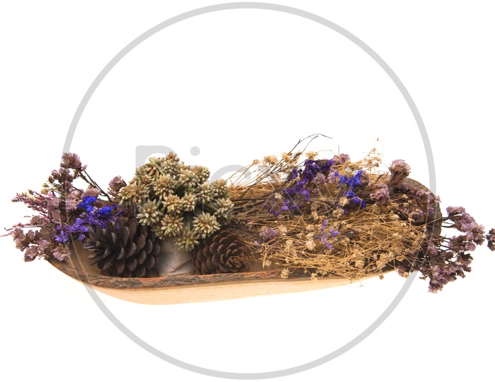 Dried vintage flowers are beautifully placed on a wooden plate white ground.