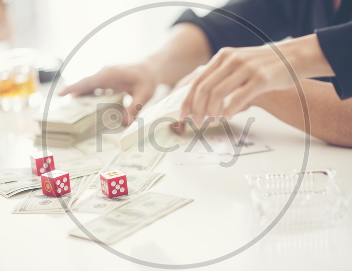 Gambling in Business With Money Bills and Dice At Office Desk Closeup And Businessman Hands Closeup